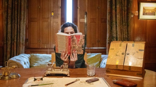 A woman sat down with a book covering her face